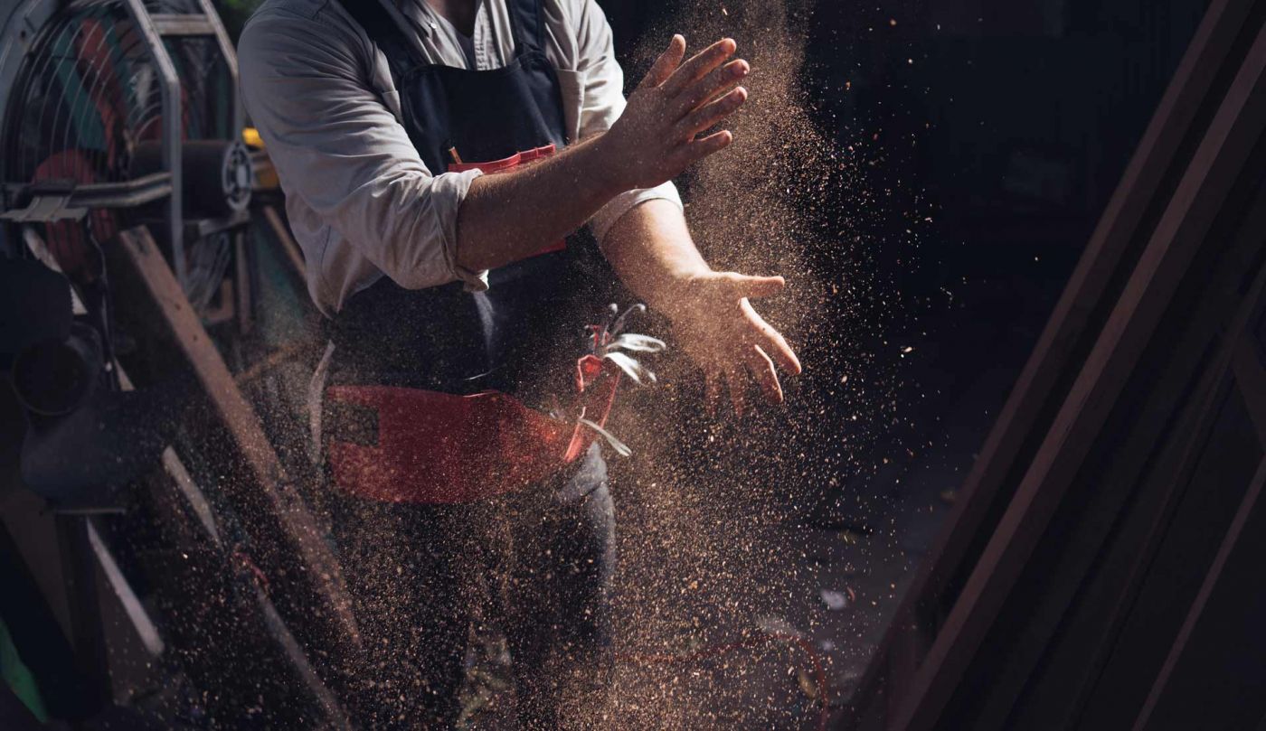 Handwerker klopft sich die Hände ab und es fliegt Staub