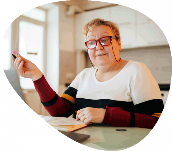 Frau mit Brille sitzt vor einem Laptop